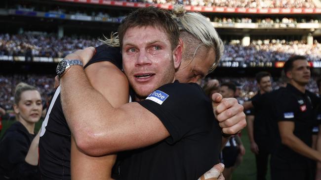 MELBOURNE, AUSTRALIA - SEPTEMBER 30: An emotional Taylor Adams of the Magpies hugs Darcy Moore of the Magpies after the 2023 AFL Grand Final match between Collingwood Magpies and Brisbane Lions at Melbourne Cricket Ground, on September 30, 2023, in Melbourne, Australia. (Photo by Daniel Pockett/AFL Photos/via Getty Images)