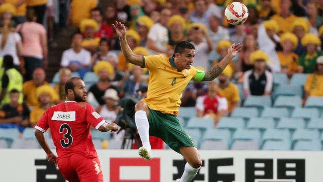 Australia's Tim Cahill heads the ball away from Oman's Jaber Al Owaisi.