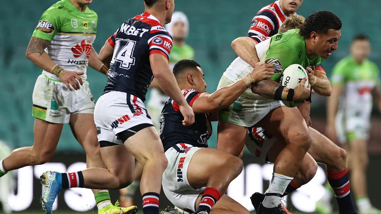 Josh Papalii of the Raiders is tackled by the Roosters
