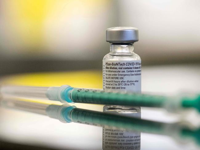 A vial containing the Covid-19 vaccine by Pfizer-BioNTech and a syringe are seen on a table in the pharmacy of the vaccination center at the Robert Bosch hospital in Stuttgart, southern Germany, on February 12, 2021. (Photo by THOMAS KIENZLE / AFP)