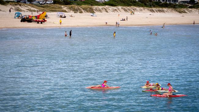 Surf lifesavers on boards in the water at Brighton Beach a day after it was closed after it was closed due to a shark sighting. Picture: Emma Brasier