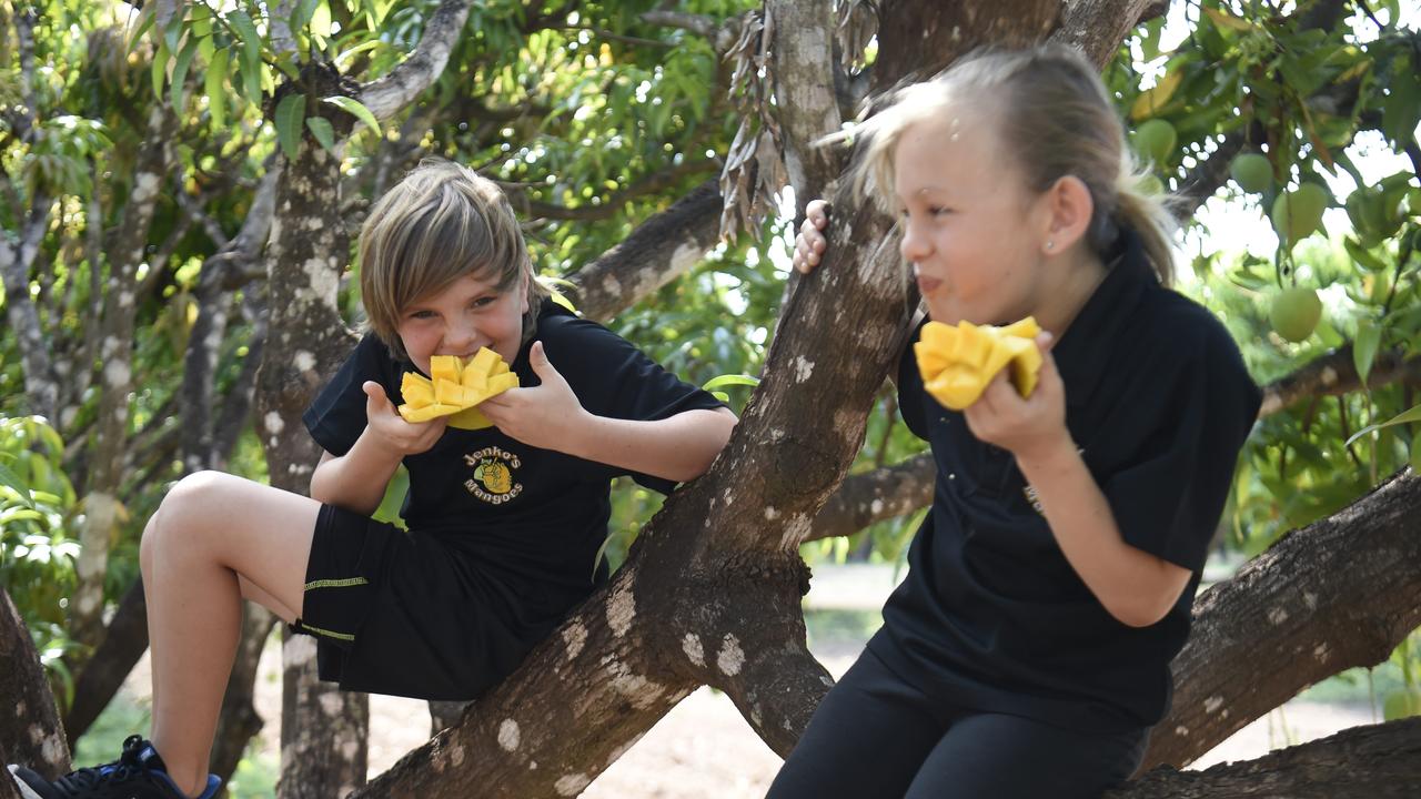 Sam and Ruby Jenkin eating the first mangoes of the season at their family farm in Noonamah.