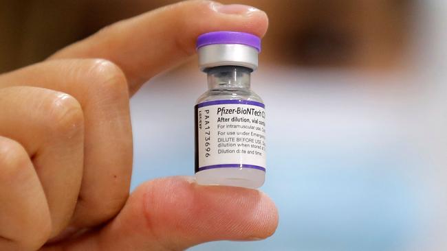 A health worker shows a vial of the Pfizer-BioNTech Covid vaccine. Picture: Javier Torres / AFP.