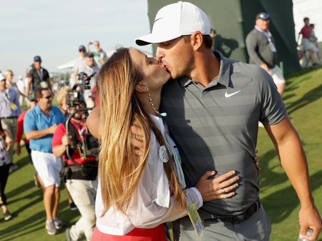 Brooks Koepka of the United States kisses girlfriend Jena Sims as they walk off the 18th green during the final round of the 2018 U.S. Open.