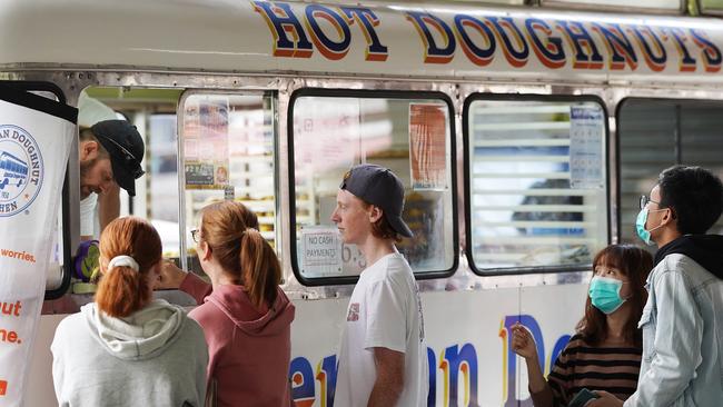 People queuing at The American Doughnut Kitchen van at Queen Vic Market. (AAP Image/Stefan Postles)