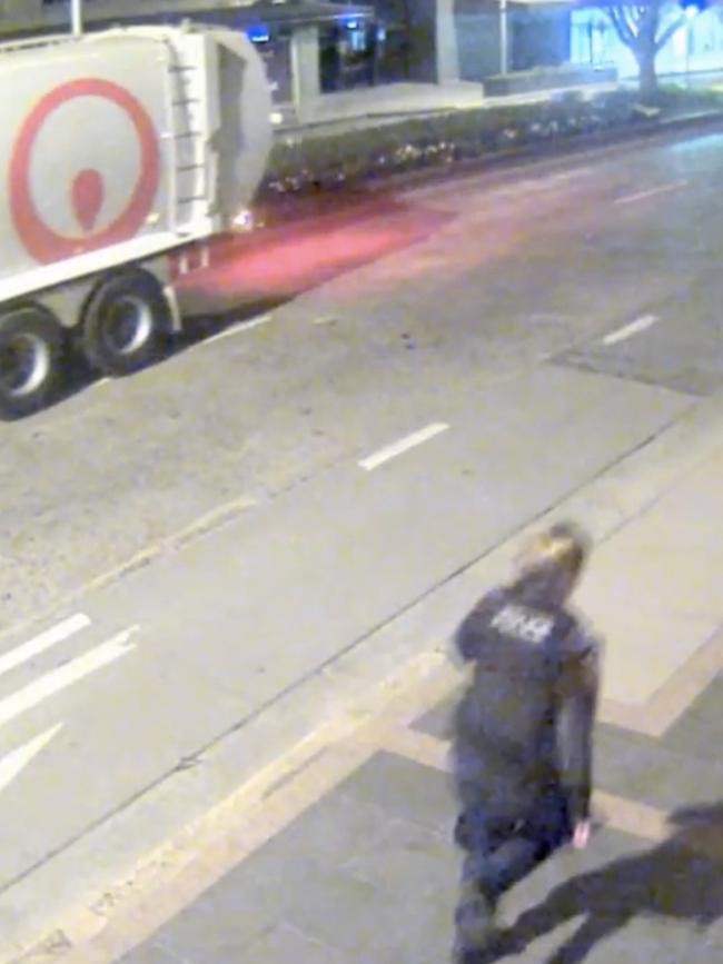 A police officer runs for cover after Warner fires at a garbage truck with a father and his young son on-board.