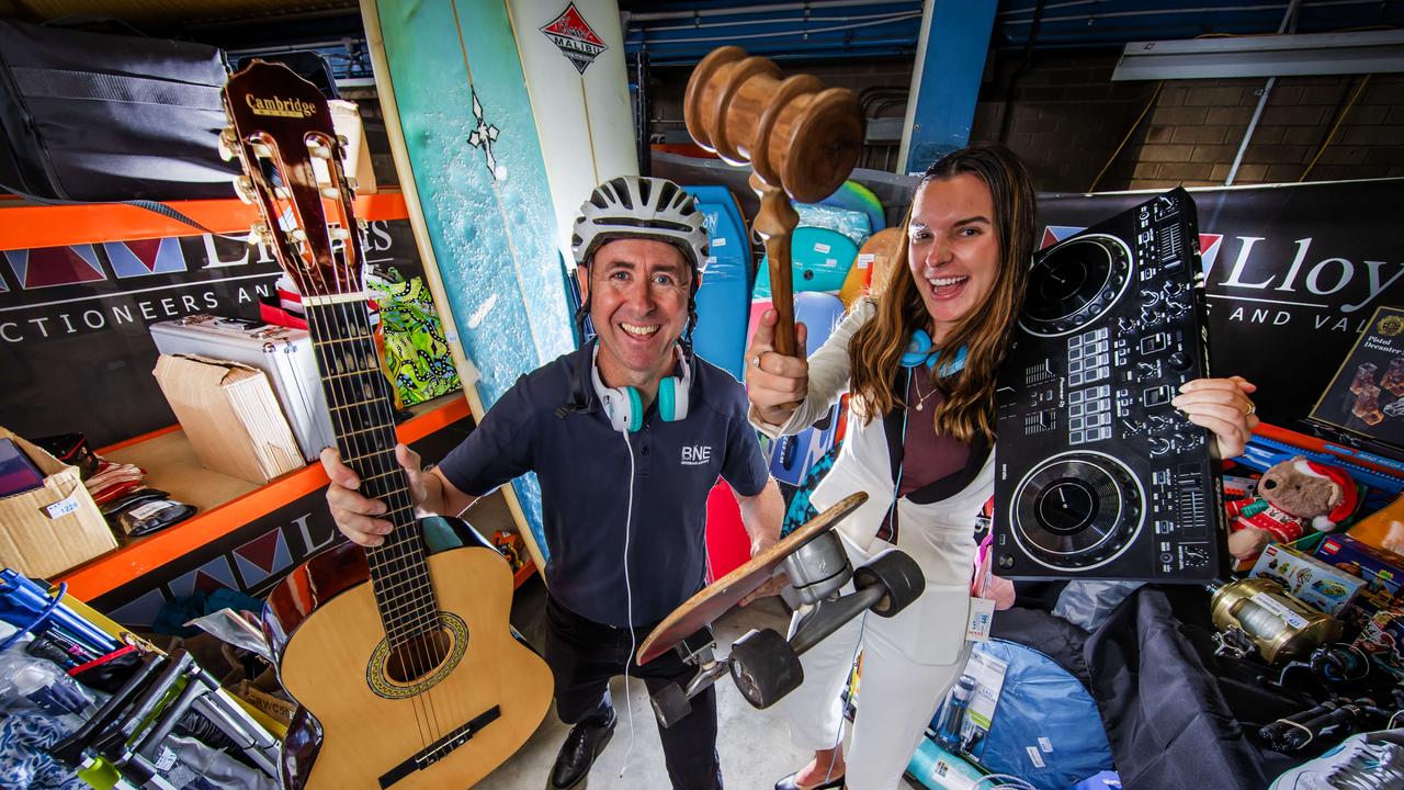 Brisbane Airport’s Peter Doherty and Taylah Gray get a glimpse of the items up for grabs ahead of the auction. Picture: Nigel Hallett