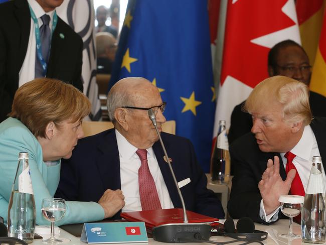 Ms Merkel, left, speaks with Tunisian President Beji Caid Essebsi and Mr Trump as they attend a round table meeting of G7 leaders in Italy. Picture: Domenico Stinellis/AP