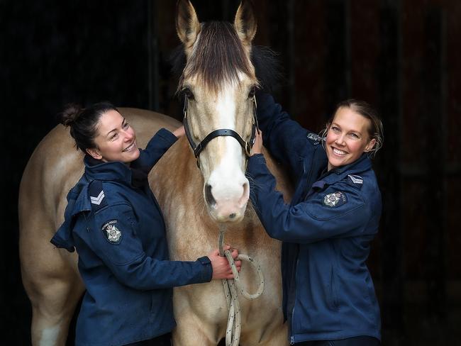 Victoria Police Mounted Branch member cuddle up with Portia in the stables. Picture: Ian Currie