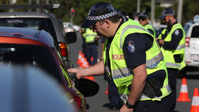 A Queensland Police officer breath and drug tests a Gold Coast driver. The Southport School’s Driving for Innovation app tracks blood alcohol levels. Picture: Regi Varghese