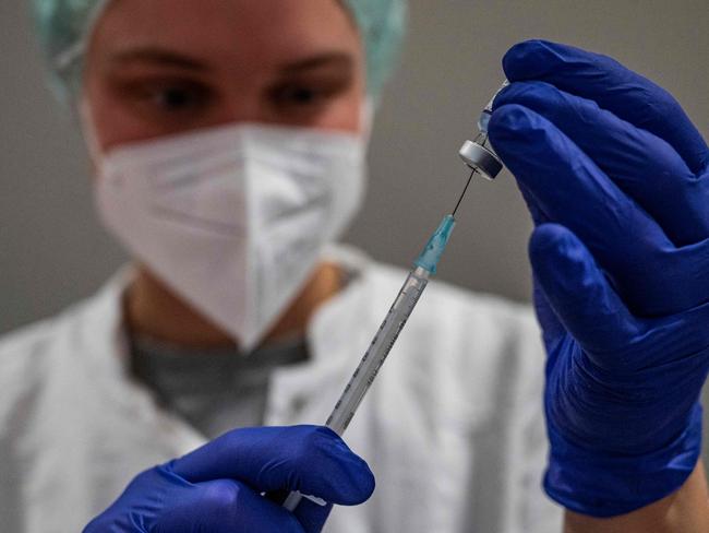 A health worker prepares a syringe with the Comirnaty Covid-19 vaccine by Biontech-Pfizer at a vaccination centre in Berlin's Humborldt Forum museum on January 18, 2022. (Photo by John MACDOUGALL / AFP)