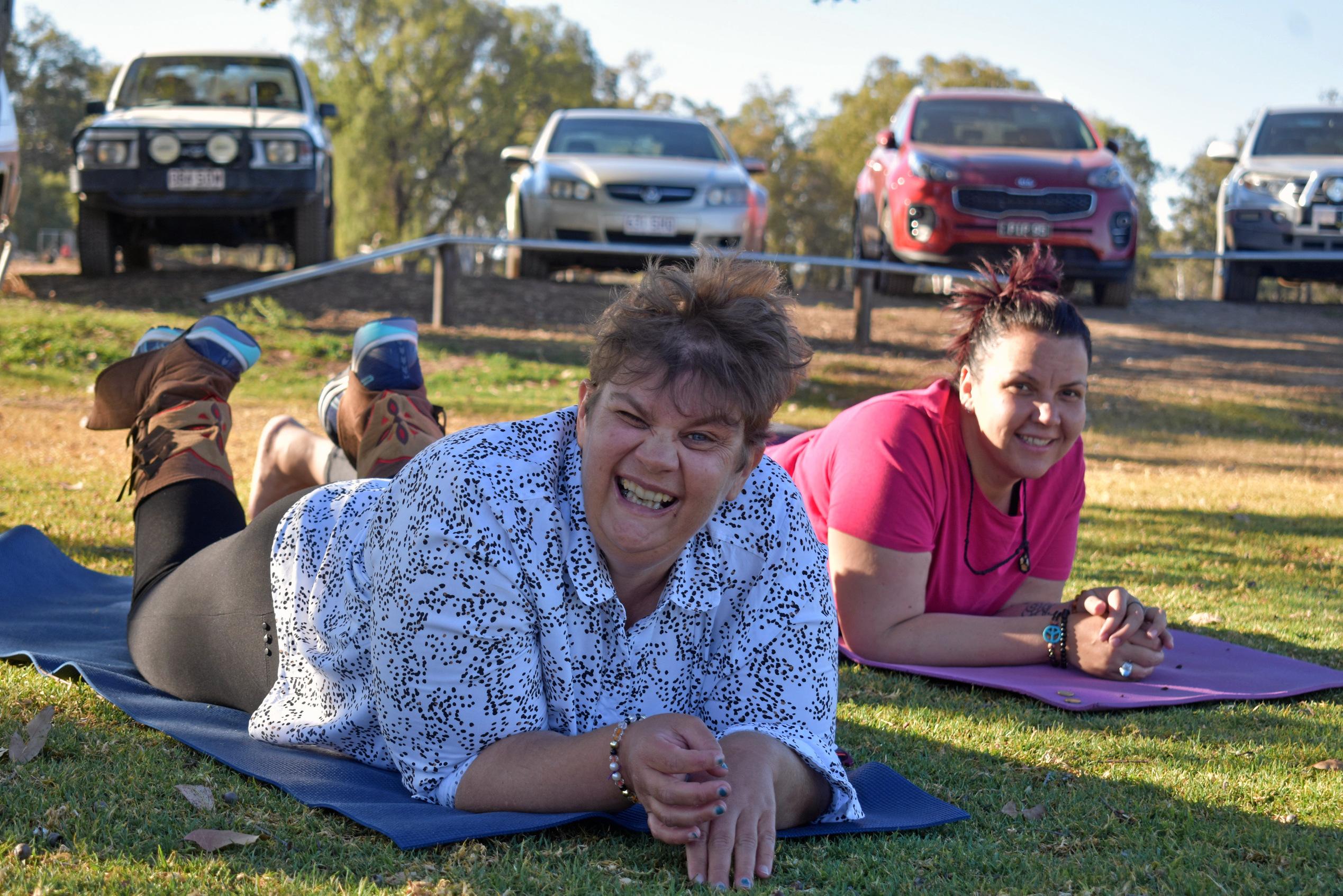 Kellie Kennedy practices her yoga with Megan Brown. Picture: Ellen Ransley