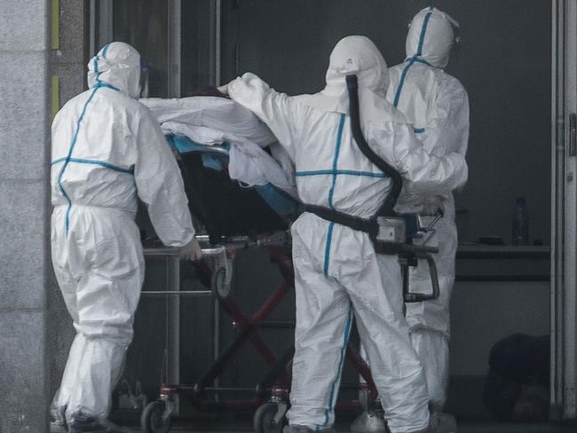 (FILES) This file photo taken on January 18, 2020 shows medical staff members carrying a patient into the Jinyintan hospital, where patients infected by a mysterious SARS-like virus are being treated, in Wuhan in China's central Hubei province. - A mysterious SARS-like virus has spread around China -- including to Beijing -- authorities said on January 20, 2020, fuelling fears of a major outbreak as millions begin travelling for the Lunar New Year in humanity's biggest migration. (Photo by STR / AFP) / China OUT