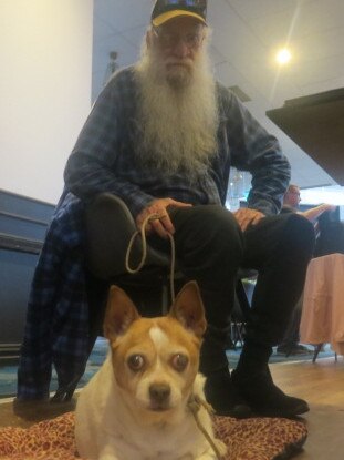 Dennis Scott and his dog at Port Panthers evacuation centre. Picture: Daniel Mills