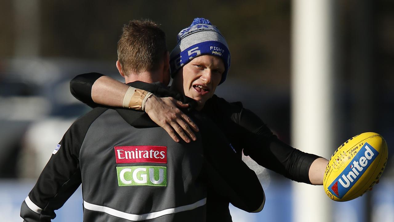 Nathan Buckley and Adam Treloar embrace during a training session in June.