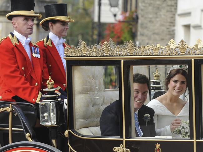 Princess Eugenie and Jack Brooksbank smile as they travel from St George's Chapel to Windsor Castle via horse carriage after their wedding. Picture: AP