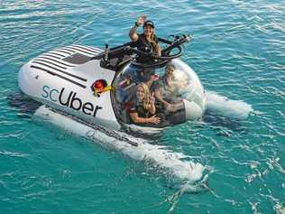 Minister for innovation, tourism industry development and the commonwealth games Kate Jones with Uber regional general manager Susan Anderson and chief pilot of ScUber Erika Bergman at the launch of ScUber, the first ride sharing submarine launched at Heron Island. Picture: Matt Taylor GLA230519SCUBER