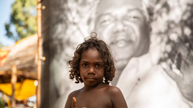 Isaiah Gurruwiwi stands before a portrait of Galarrwuy Yunupingu in remote northeast Arnhem Land. The Gumatj people are one large step closer to securing their survival in a much harsher world than the one Dr Yunupingu experienced during his life. Picture: Leicolhn McKellar