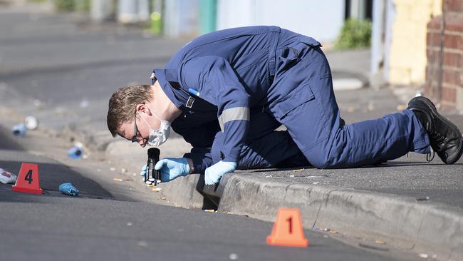 Forensic police examine items at the scene of a multiple shooting outside Love Machine nightclub. Picture: AAP Image/Ellen Smith