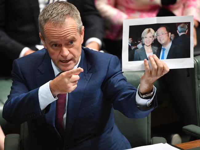 Leader of the Opposition Bill Shorten holds a photograph of former foreign affairs minister Julie Bishop with Mr Huang during Question Time in June 2017. Picture: AAP