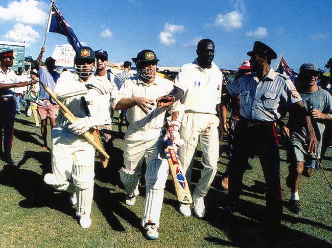 Taylor and Michael Slater are helped from the ground in Barbados by police after Australia winning the first Test.