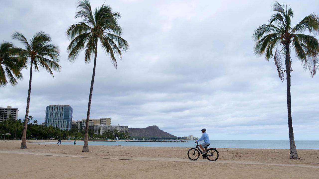 A cyclist rides along an empty Waikiki Beach on July 26, 2020. Picture: Ronen Zilberman / AFP