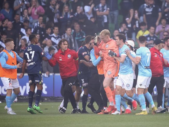 Then Melbourne City goalkeeper Tom Glover is escorted from the ground after being assaulted during the pitch invasion at AAMI Park in December last year. Picture: Dave Hewison/Speed Media/Icon Sportswire via Getty Images