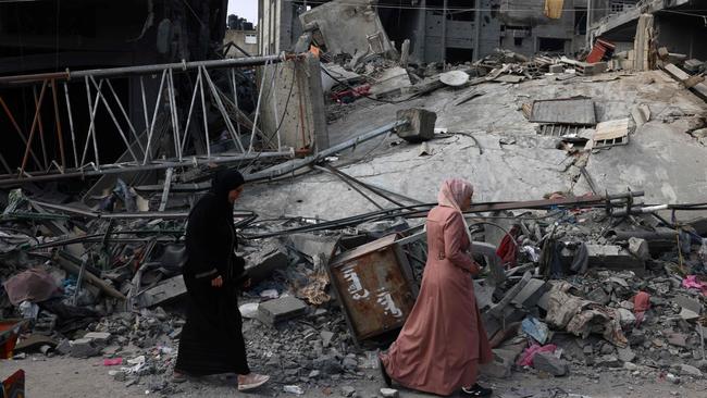 Women walk past a destroyed building in the aftermath of Israeli bombing in Rafah in the southern Gaza Strip on Saturday. Picture: Said Khatib/AFP