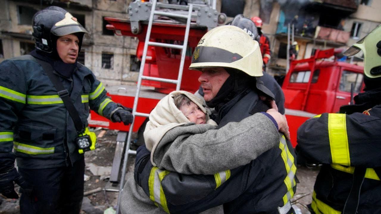 Rescuers help a woman evacuate a residential building that was struck, as Russia's attack on Ukraine continues, in Kyiv, Ukraine. Picture: Reuters