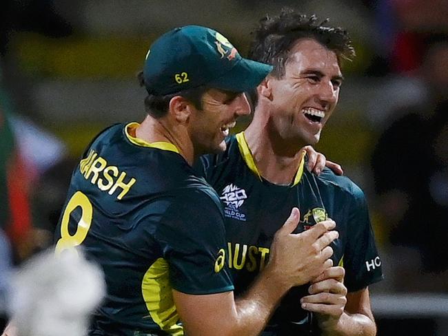 ANTIGUA, ANTIGUA AND BARBUDA - JUNE 20: Pat Cummins of Australia celebrates with teammates Mitchell Marsh and Tim David  after dismissing Taskin Ahmed of Bangladesh for his hat trick during the ICC Men's T20 Cricket World Cup West Indies & USA 2024 Super Eight match between Australia and Bangladesh at Sir Vivian Richards Stadium on June 20, 2024 in Antigua, Antigua and Barbuda. (Photo by Gareth Copley/Getty Images)