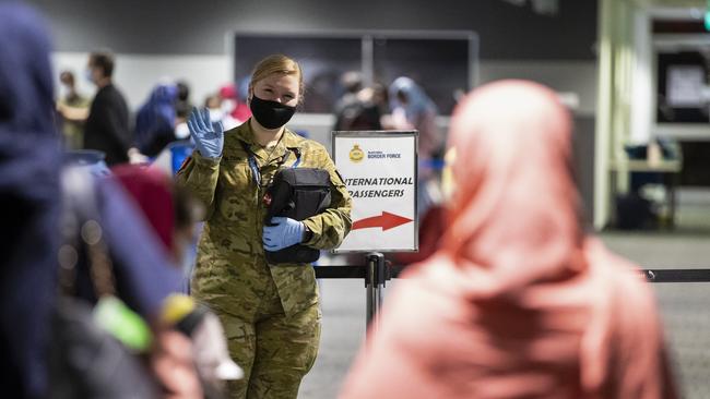 Australian citizens and visa holders evacuated from Afghanistan are assisted off their flight by Australian Defence members in late August.