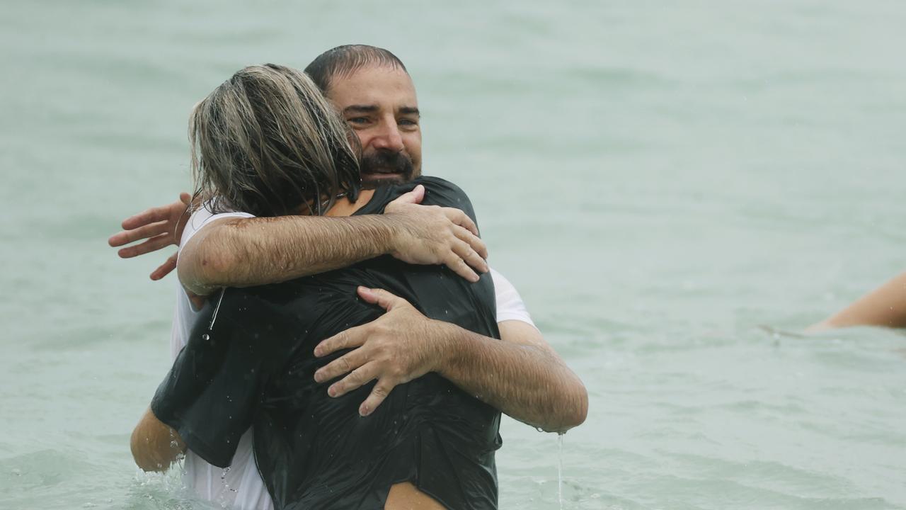 Father Michael Stewart receives a hug in the water at the tribute for his son, Balin Stewart, at Buddina. Picture: Lachie Millard