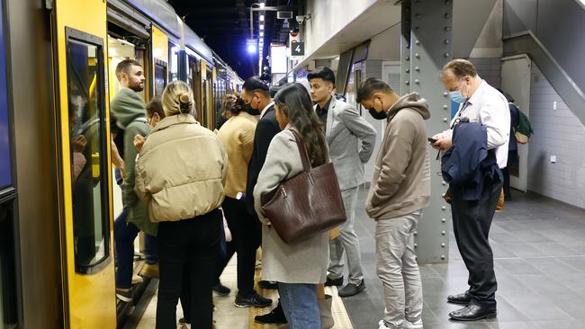 In the crush of the daily commute at Town Hall Station in Sydney, some passengers wear masks while others do not – despite the threat of a fine. Picture: Richard Dobson