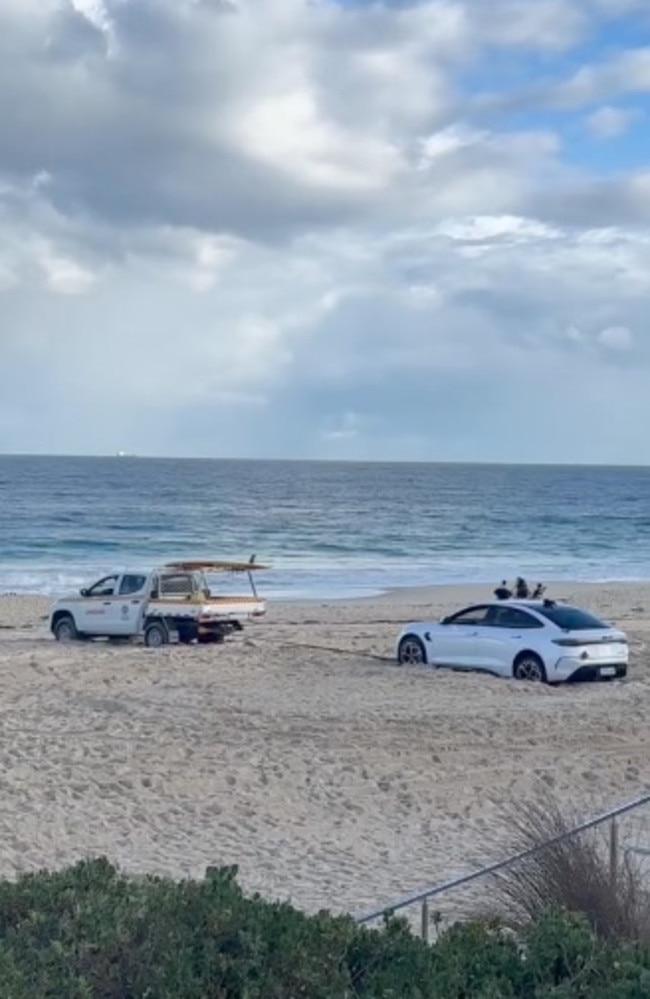 The bogged EV spent the night on Perth’s popular City beach as a ute tried to help pull it off the sand the next morning. Picture: Facebook/TheBellTowerTimes