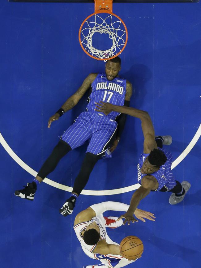 Ben Simmons, centre, goes up for a shot against Orlando Magic's Mohamed Bamba, and Jonathon Simmons looks on during the first half of a preseason NBA basketball game. Picture: AP Photo