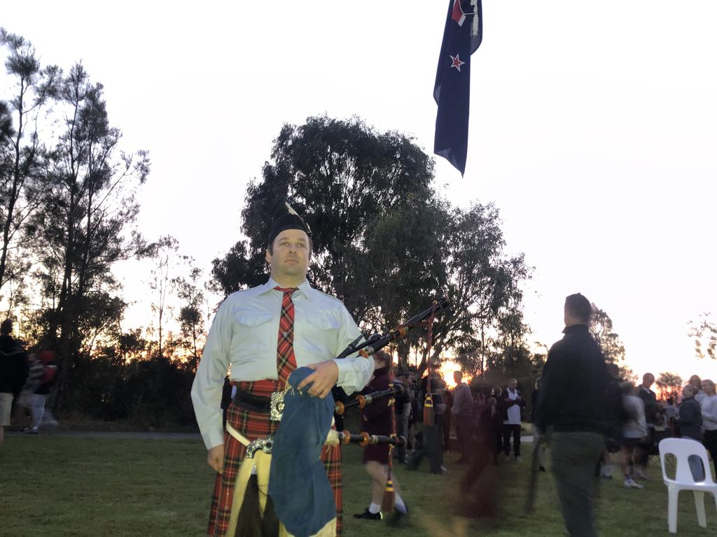 Matthew Fisher from the Brisbane Thistle Pipe Band plays Flowers of the Forest lament as dawn breaks at Redland Bay on AnZAC Day 2024. Picture: Judith Kerr