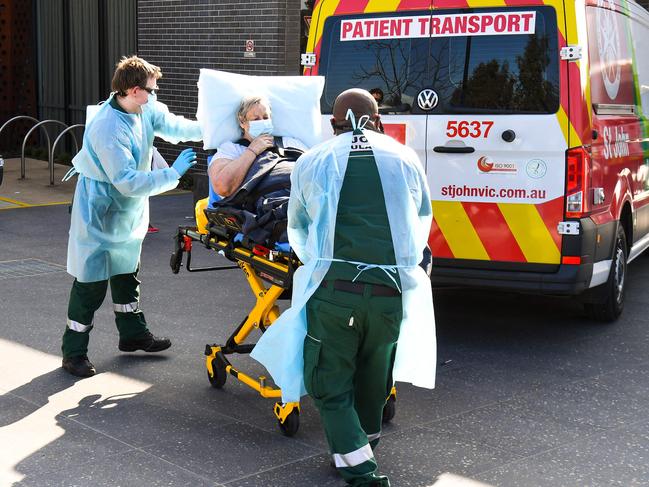 Ambulance officers transport a resident from the Epping Gardens aged care facility. Picture: AFP