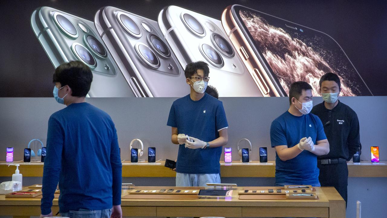 Apple workers aren’t supposed to wear their uniforms outside the store. Staff at this recently reopened Beijing store have added masks to protect against the coronavirus outbreak. Picture: AP Photo/Mark Schiefelbein