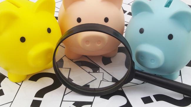 Three piggy banks under magnifying glass on question marks background. Saving money concept; superannuation saving generic