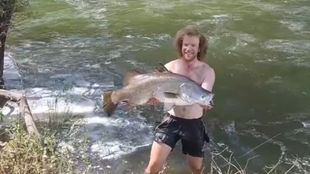 Tom Hallam holds up the fish as a crowd cheers from the bank. Picture: Jess Bell