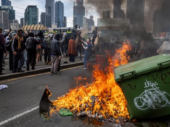 Anti-war activists protest the Land Forces 2024 International Land Defence Exposition at the Melbourne Convention and Exhibition Centre. Protesters attempt to establish a burning barricade on the Clarendon Street Bridge. Picture: Jake Nowakowski