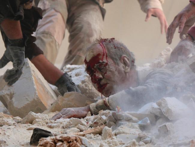 EDITORS NOTE: Graphic content: Syrian rescue workers and residents try to pull a man out from under the rubble of a building following a reported air strike on the rebel-held neighbourhood of Salhin in the northern city of Aleppo on March 11, 2016. Picture: AFP PHOTO / THAER MOHAMMED