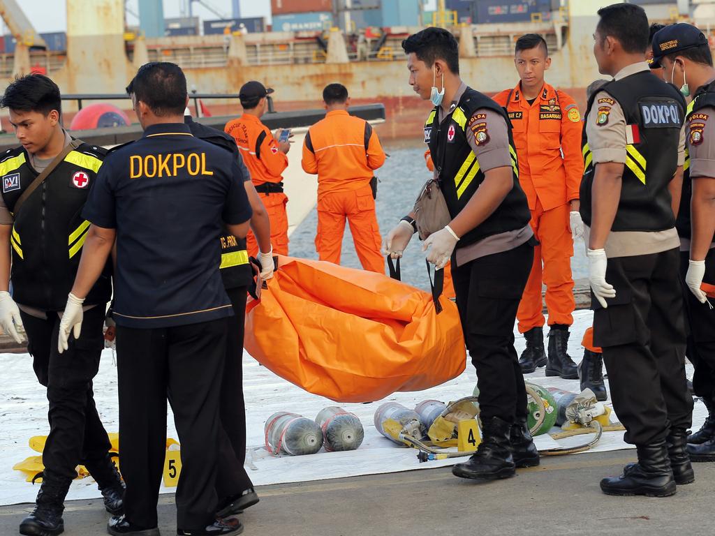 Police officers carry a body bag containing the remains recovered from the area where a Lion Air passenger jet crashed, at Tanjung Priok Port in Jakarta. Picture: AP/Tatan Syuflana