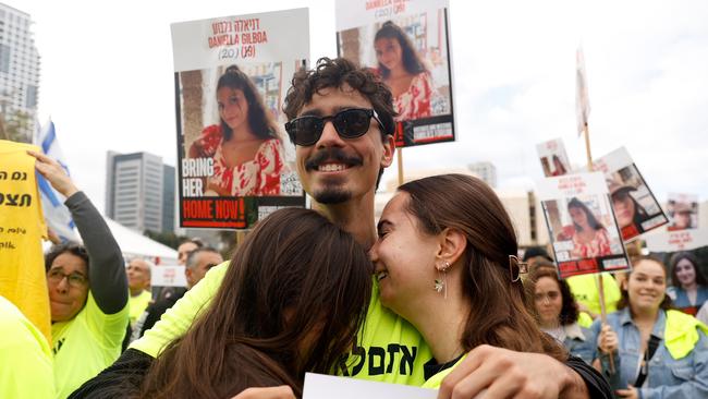 People hold photos of the four Israeli hostages in Tel Aviv on Saturday. Picture: Getty Images