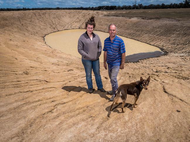 Farmer Steve Harrison, his daughter Megan and dog Dougie at the farm's almost dry dam. Picture: Jake Nowakowski