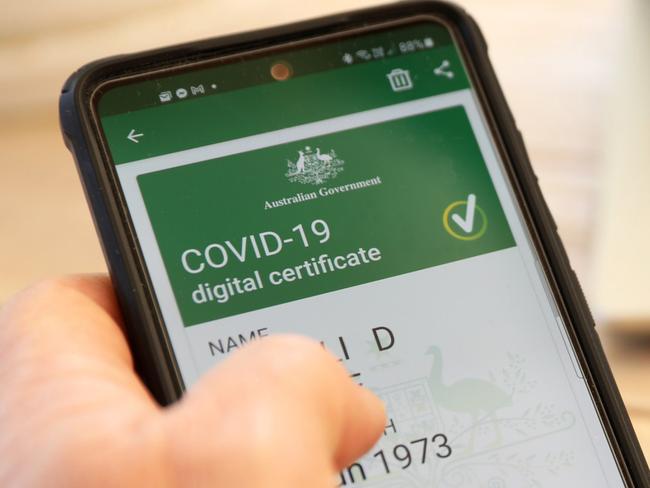 Australia 09-09-2021. Official Commonwealth of Australia Government digital proof of covid-19 vaccination certificate on a mobile phone device. Passport blurred in background and laptop.