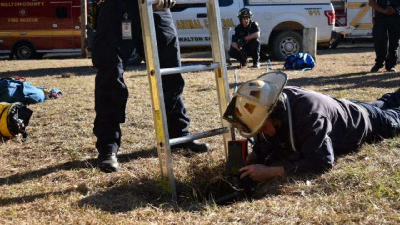 Rescue workers from a fire department in Florida rescued a pooch after it got trapped in a 4 metre hole. Picture: Facebook/South Walton Fire District