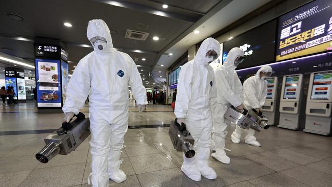 Health workers wearing protective gears spray disinfectant as part of efforts to prevent the spread of a new virus which originated in the Chinese city of Wuhan, at a bus terminal in Gwangju on January 28, 2020. (Photo by - / YONHAP / AFP)