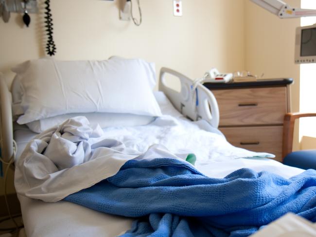 Empty hospital bed at a single hospital room