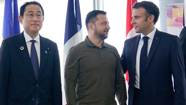 French President Emmanuel Macron (R) talks with Ukraine's President Volodymyr Zelensky (C) as Japanes PM Fumio Kishida (L) waits for a photo during the G7 Leaders' Summit in Hiroshima. Picture: AFP